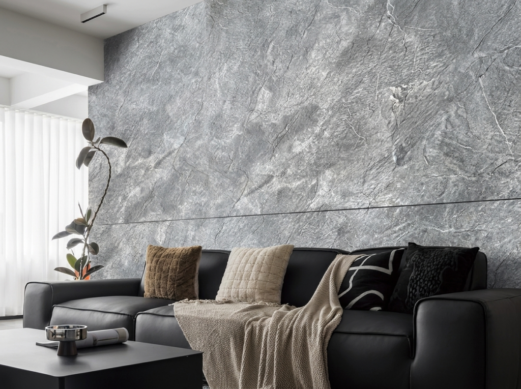 Living room with a large grey veined stone-finish wall and black leather sofa